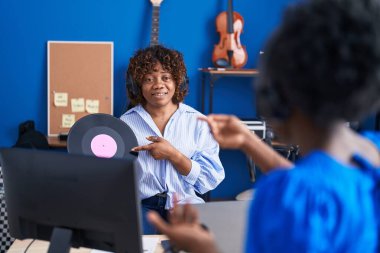 Müzik stüdyosunda konuşan Afrikalı Amerikalı kadın müzisyenler.