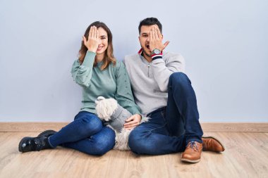 Genç İspanyol bir çift yerde oturuyor. Köpekleri bir gözünü eliyle kapatıyor. Yüzünde kendine güvenen bir gülümseme ve sürpriz bir duygu var.. 