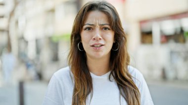 Sokakta ciddi bir ifadeyle duran genç, güzel İspanyol kadın.