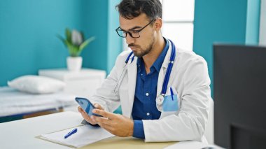 Genç İspanyol doktor, klinikte çalışan akıllı telefonu kullanıyor.