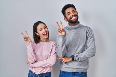 Genç İspanyol çift kameraya göz kırparak gülümsüyor parmaklarıyla zafer işareti yapıyor. İki numara.. 