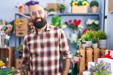 Çiçekçide kendine güvenen genç kel bir çiçekçi.