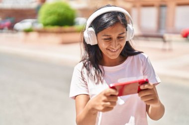 Genç, güzel İspanyol kadın gülümsüyor. Sokakta oyun oynarken kendine güveniyor.