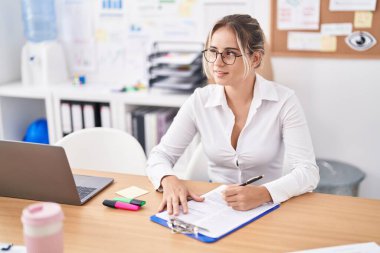 Genç sarışın iş kadını gülümsemesi ofisteki panoda kendine güvenen bir yazı.