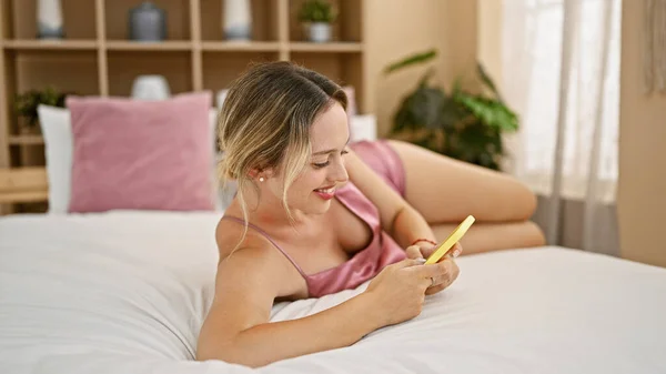 Mujer Rubia Joven Usando Teléfono Inteligente Acostado Cama Dormitorio — Foto de Stock