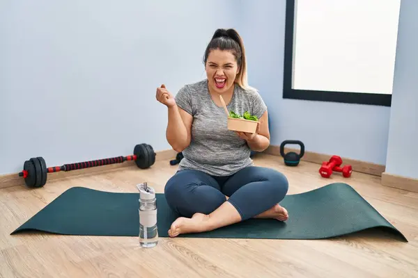 Ung Latinamerikansk Kvinna Sitter Yogamatta Äta Hälsosam Sallad Skriker Stolt — Stockfoto