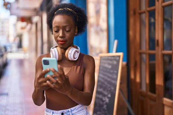 Afričanky Americká Žena Nosí Sluchátka Pomocí Smartphone Ulici — Stock fotografie