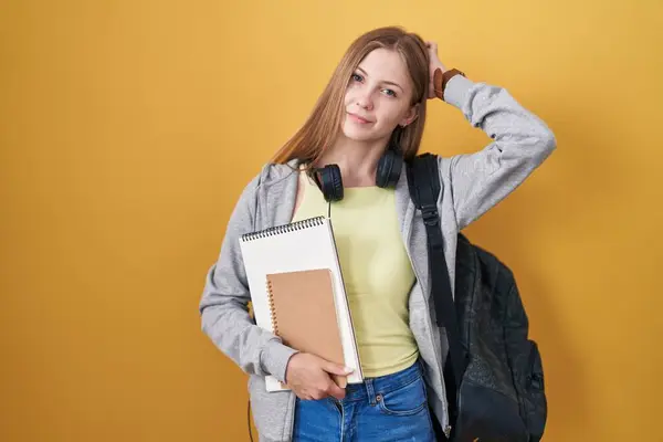 Young Caucasian Woman Wearing Student Backpack Holding Books Confuse Wondering — Zdjęcie stockowe