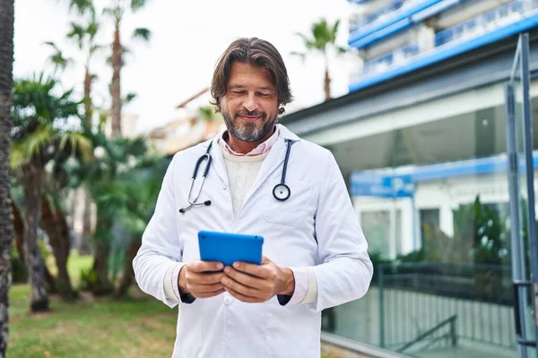 Чоловік Середнього Віку Лікар Посміхається Впевнено Використовуючи Тачпад Лікарні — стокове фото