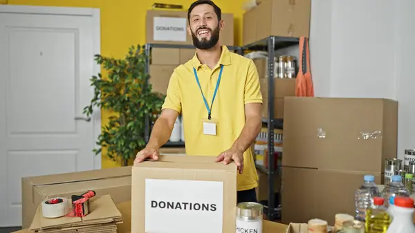 Joven Hombre Hispano Voluntario Sonriendo Confiado Pie Centro Caridad — Foto de Stock