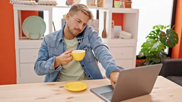 年轻的高加索人在饭厅用笔记本电脑用智能手机喝咖啡 — 图库照片