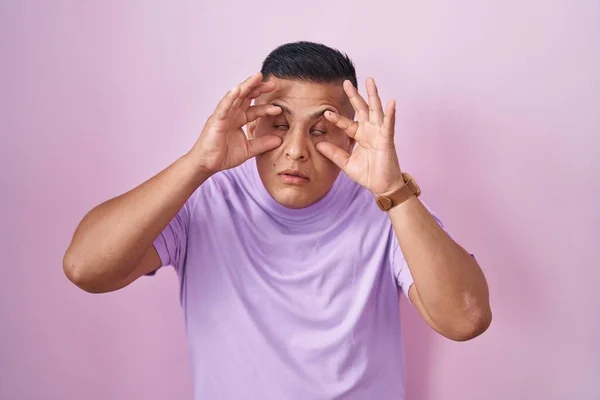 Young Hispanic Man Standing Pink Background Trying Open Eyes Fingers — Stock Photo, Image