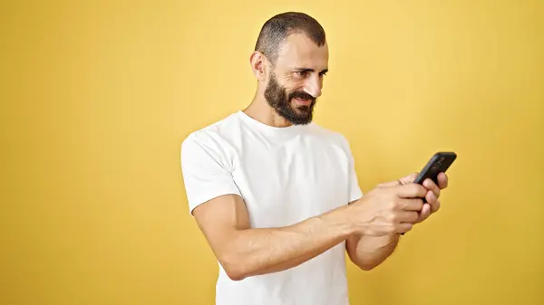 Joven Hombre Hispano Usando Smartphone Sonriendo Sobre Aislado Fondo Amarillo —  Fotos de Stock