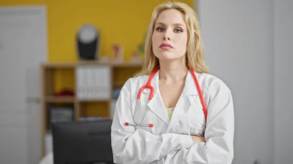 Young Blonde Woman Doctor Standing Serious Expression Arms Crossed Gesture — Stock Photo, Image