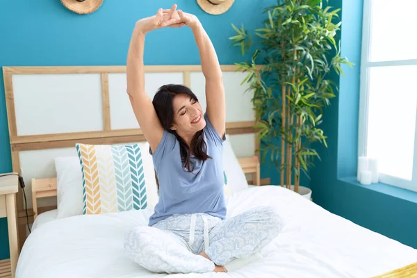 Middle Age Hispanic Woman Waking Stretching Arms Bedroom — Φωτογραφία Αρχείου