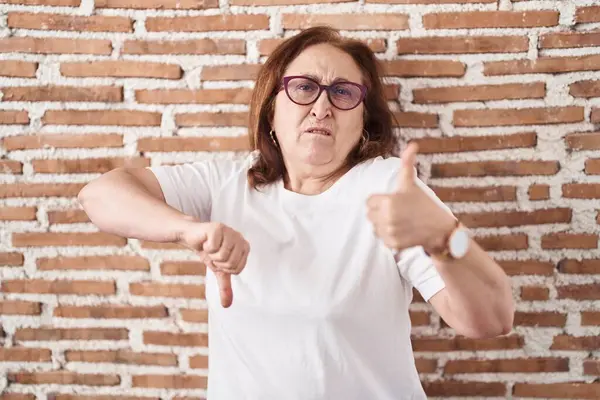 Mujer Mayor Con Gafas Pie Sobre Pared Ladrillos Haciendo Pulgares —  Fotos de Stock