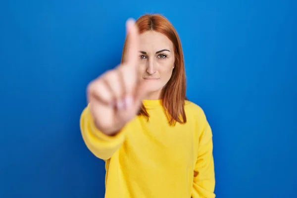 Mavi Arka Planda Duran Genç Bir Kadın Parmağını Kaldırmış Kızgın — Stok fotoğraf