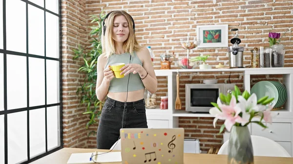 若い金髪の女性は 音楽を聴き ダイニングルームでコーヒーを飲むダンス — ストック写真
