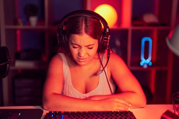 若い金髪の女性は 消化不良 痛みを伴う病気を感じるため 胃にヘッドフォンを着用したビデオゲームをプレイしています アチェのコンセプト — ストック写真