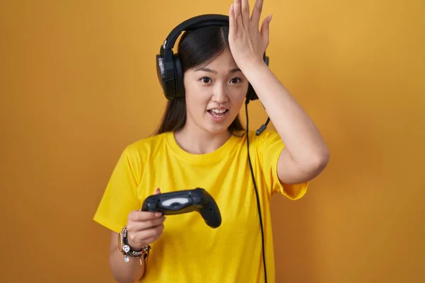 中国的年轻女子玩电子游戏时 手持控制器对手头上的错误感到惊讶 记错了 坏的记忆概念 — 图库照片
