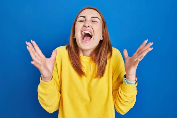 Mavi Arka Planda Duran Genç Bir Kadın Başarının Çılgınlığını Kutluyor — Stok fotoğraf