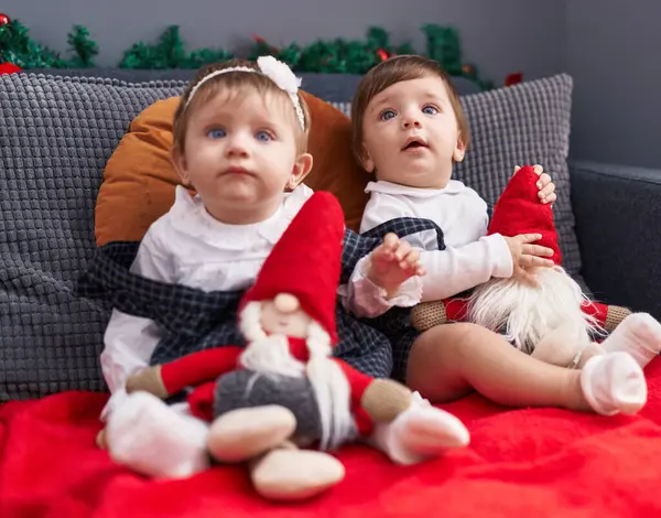 Два Прелестных Ребенка Сидят Диване Играют Куклой Санта Клауса Дома — стоковое фото