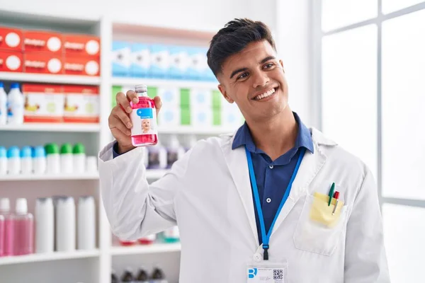 Young Hispanic Man Pharmacist Smiling Confident Holding Medication Bottle Pharmacy — Zdjęcie stockowe