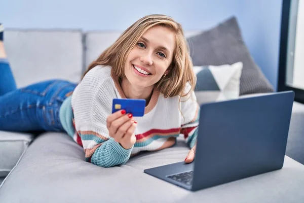 Jovem Loira Usando Laptop Cartão Crédito Deitado Sofá Casa — Fotografia de Stock