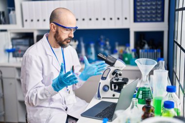 Genç kel bilim adamı laboratuarda video görüşmesi yapıyor.