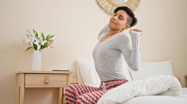 Genç, güzel İspanyol bir kadın yatak odasında kollarını açarak uyanıyor.