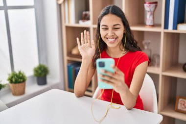 Genç Brezilyalı bir kadın akıllı telefonuyla video çekiyor. Pozitif ve mutlu görünüyor. Kendine güvenen bir gülümsemeyle dişlerini gösteriyor. 