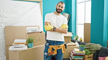 Genç İspanyol tamirci gülümsüyor. Kendine güvenen. Yeni evinde kollarını kavuşturup el kol hareketi yapıyor.