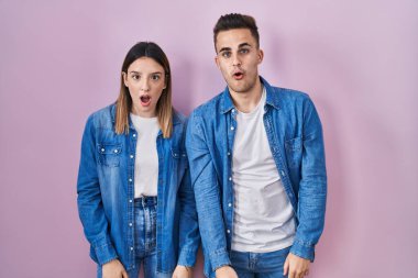 Pembe arka planda duran genç İspanyol çift şaşkınlık ve şaşkınlık dolu ifade, korku ve heyecan dolu yüz ifadeleriyle dehşete düşmüş ve şok olmuştu.. 