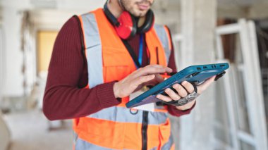 İnşaat alanında dokunmatik ped kullanan genç İspanyol müteahhit.