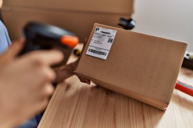 Young blond man ecommerce business worker scanning package at office