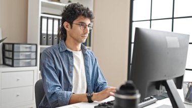 Young hispanic man business worker using computer working at office