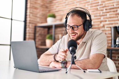 Young hispanic man radio reporter working at home