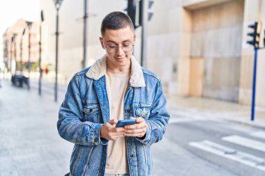 Sokakta akıllı telefon kullanan, kendine güvenen genç bir İspanyol.