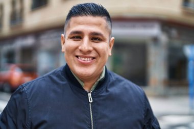 Young latin man smiling confident standing at street