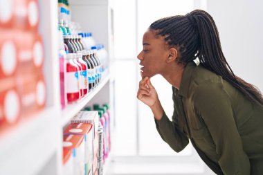 African american woman customer looking medicine bottle at pharmacy
