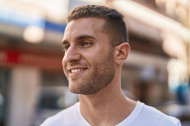 Young caucasian man smiling confident looking to the side at street