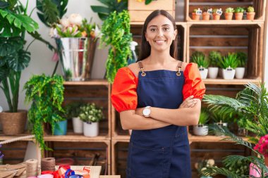 Çiçekçiye kollarını kavuşturup gülümseyen güzel İspanyol kadın.
