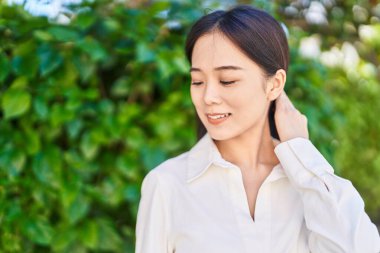 Young chinese woman smiling confident looking to the side at park
