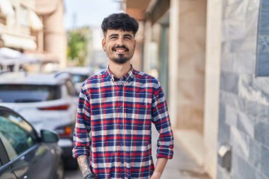 Sokakta kendinden emin gülümseyen İspanyol genç adam.