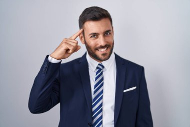 Yakışıklı İspanyol takım elbiseli ve kravatlı adam tek parmağıyla başını gösteren, harika bir fikir ya da düşünce, iyi bir hafıza. 