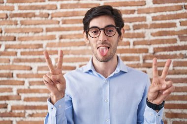 Duvarın arkasında dikilmiş, ağzı açık gülümseyen genç bir İspanyol zafer işareti yapıyor. İki numara.. 