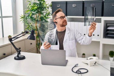 Kafkasyalı genç bir doktor klinikteki masada oturuyor.