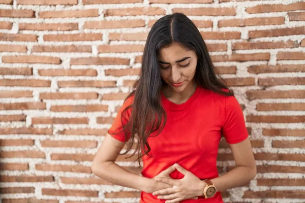 少女站在砖墙上 手放在肚子上 因为消化不良 痛苦不堪 疼痛的概念 — 图库照片