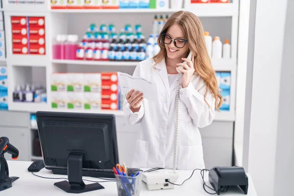 Молодая Женщина Фармацевт Разговаривает Телефону Читая Рецепт Аптеке — стоковое фото