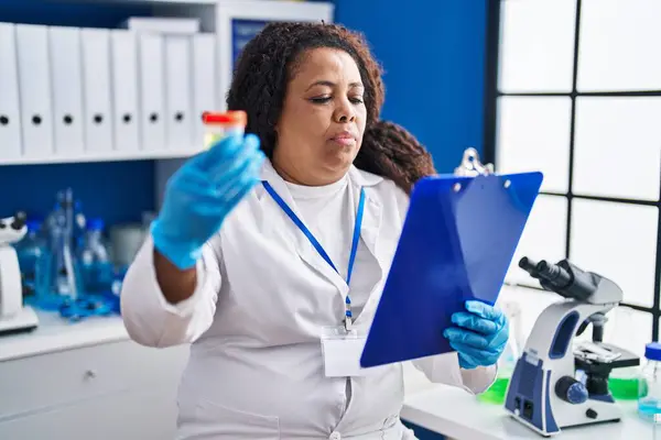 African American Woman Scientist Reading Document Holding Urine Test Tube — Stock Photo, Image